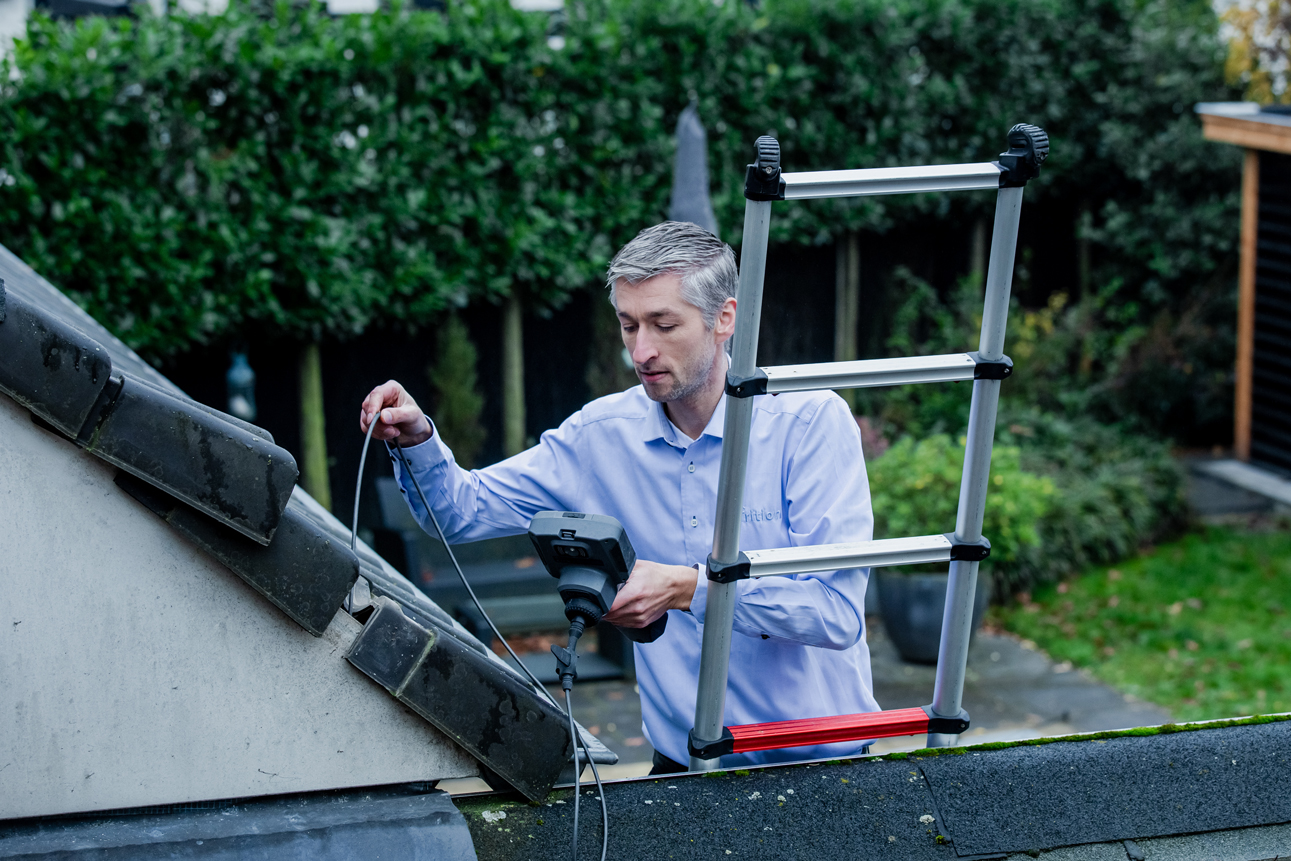 Op een dak testen hoe waterschade is ontstaan